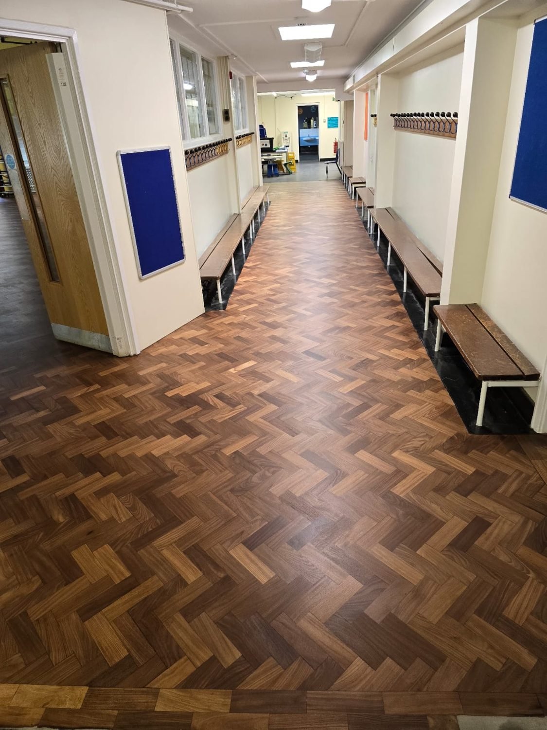 Refinished herringbone parquet in a school hallway in Croydon