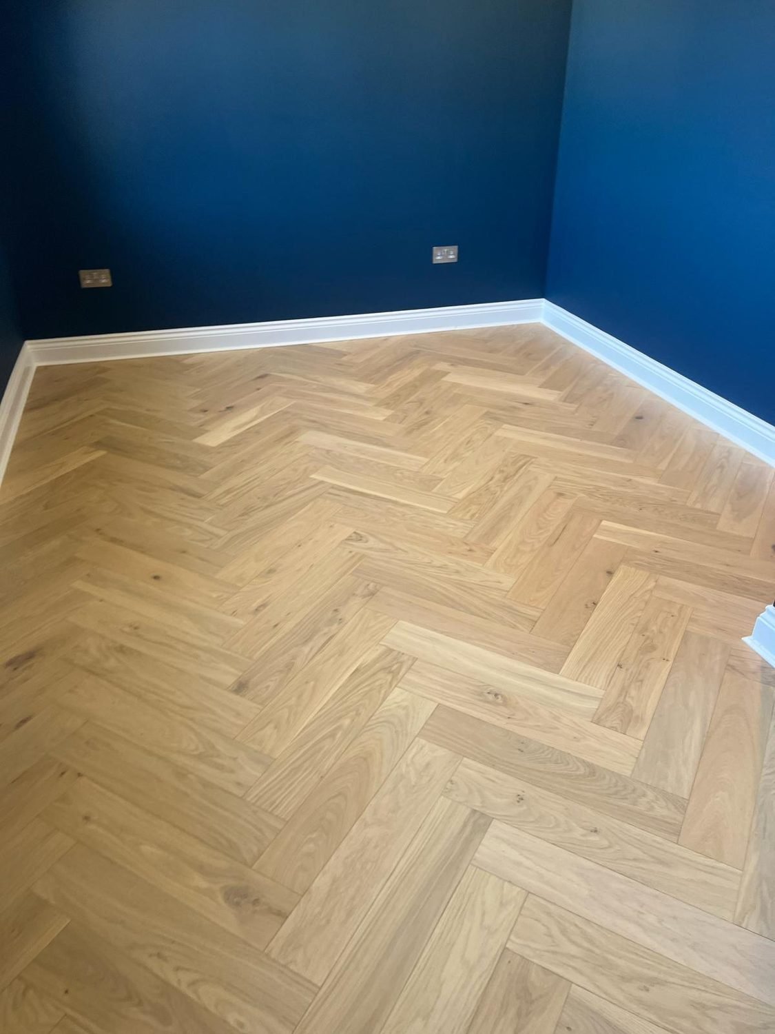 Close-up of a new oak herringbone floor installation in Hackney