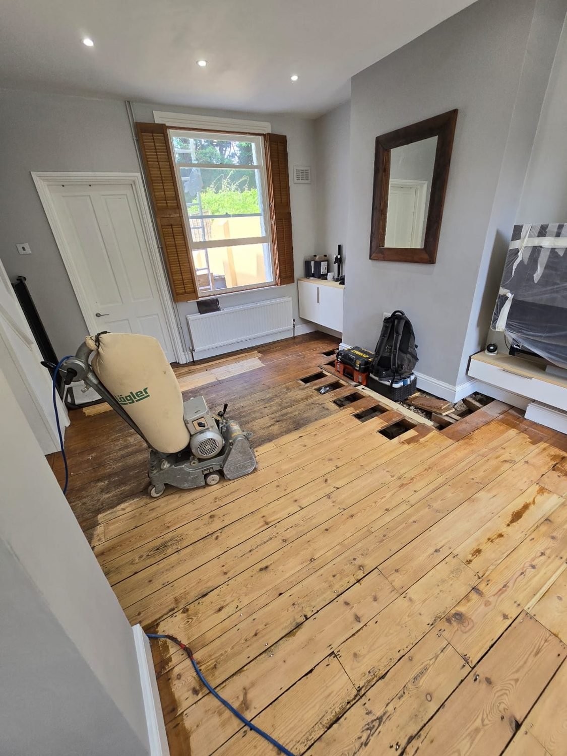 Sanding pine floorboards during restoration in Wandsworth