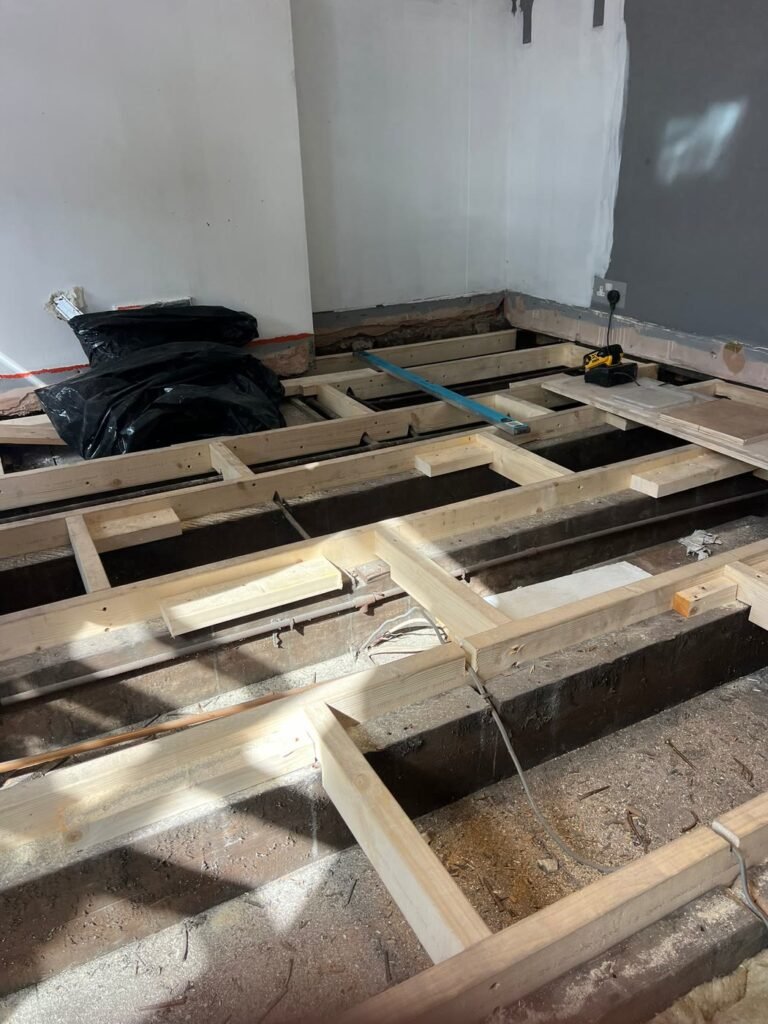 Old floor removed and disposed of, floor joists exposed in East London E7