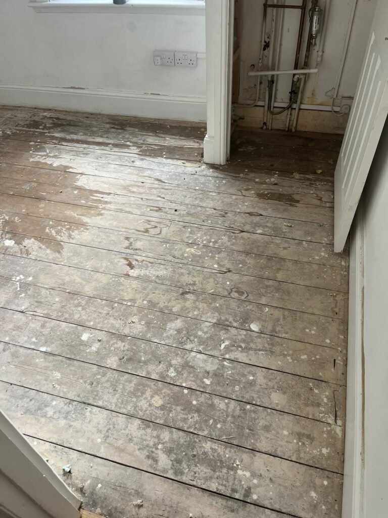 Carpet lifted and old floorboards exposed before the new floor was fitted