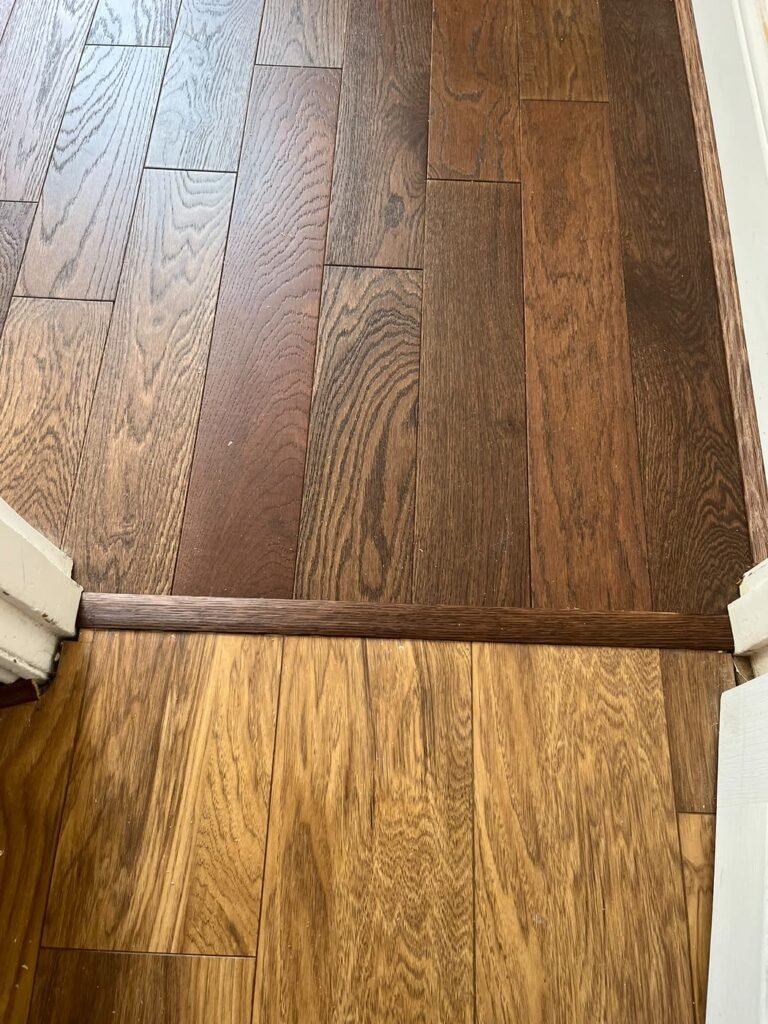 New door threshold fitted between the new floor and the existing hallway floor